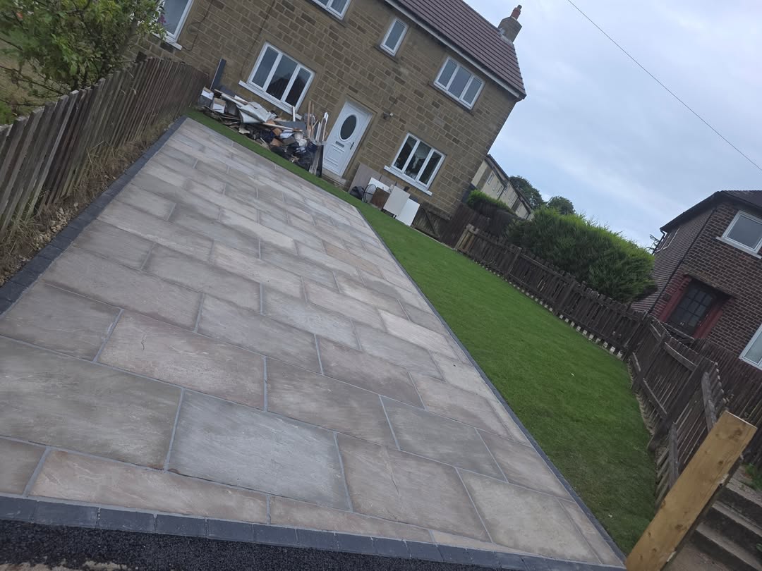 Large grey paved area beside a lawn