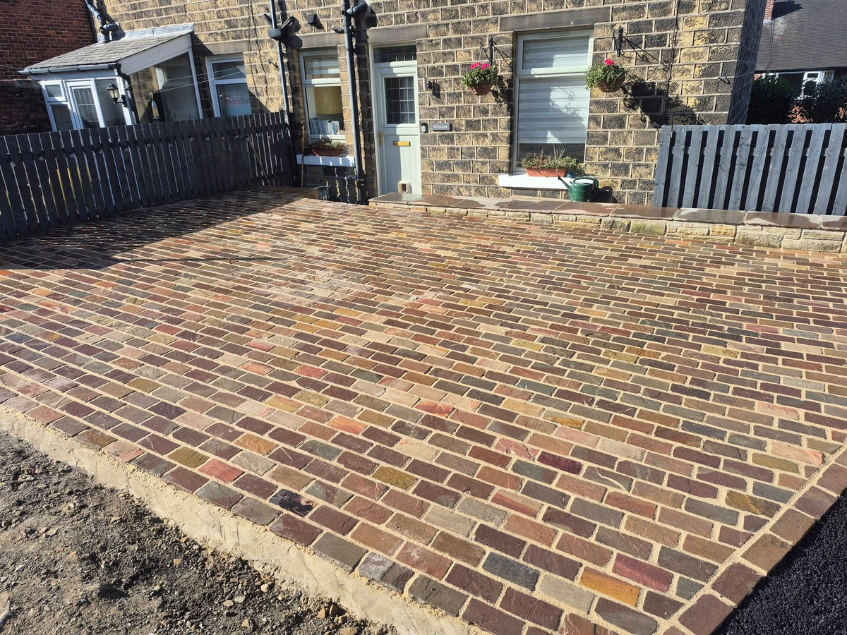 Traditional stone sett driveway outside a stone house