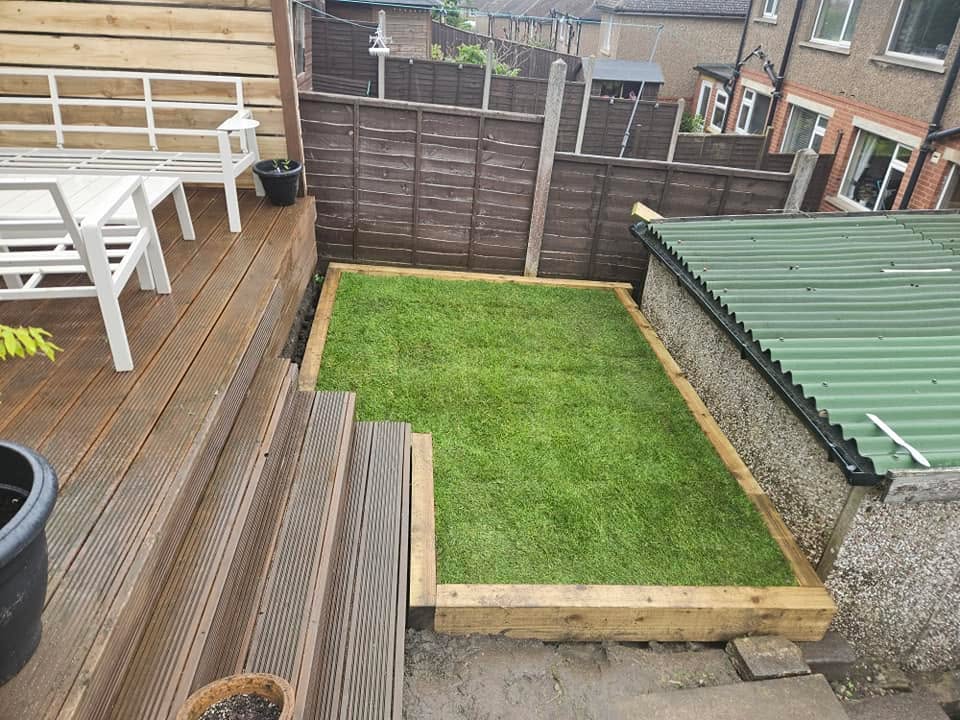 Timber decking with sleeper-edged lawn and boundary fencing