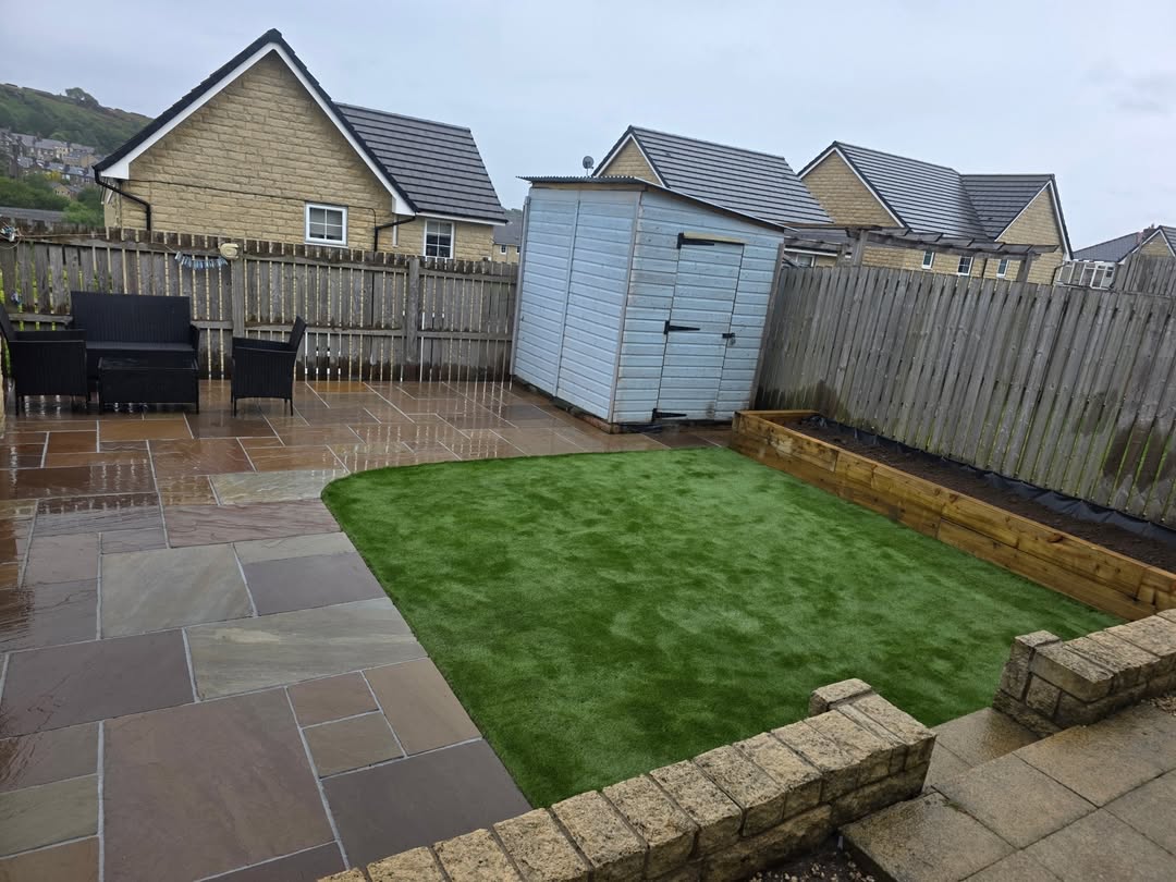 Lawn surrounded by stone paving and sleeper edging